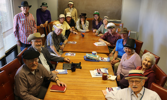 Members of the Humanist Group around a large conference table, wearing hats